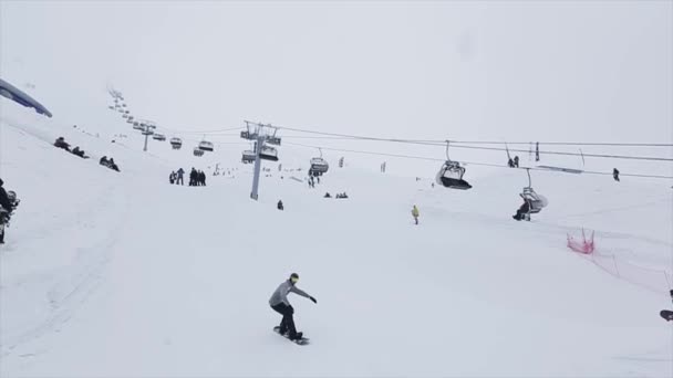 Sochi, Ryssland - den 29 mars 2016: Snowboardåkare hoppa på språngbräda, göra knäppa på ski resort i bergen. Extrema stunt. Personer. Lutning — Stockvideo