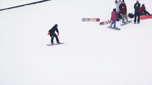 Sochi, Rusko - 29 března, 2016: Snowboardista jízda na železnou stezkou na svahu. Zasněžené hory. Příznaky. Soutěž. Lidé. Extrémní sport. — Stock video