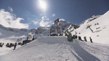 Soçi, Rusya - 1 Nisan 2016: Snowboarder sıçrama tahtasından düşüyor. Turuncu top. Seyirci. Kayak. Güneşli