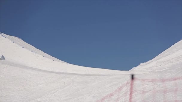 ソチ、ロシア - 4月 1, 2016: スキーヤーは、スプリングボードから高いジャンプを行い、空気中の足を曲げる.スキー場山 — ストック動画