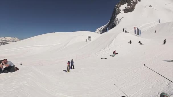 SOCHI, RUSIA - 1 DE ABRIL DE 2016: Snowboarder hacer saltar en la bola de lanzamiento de trampolín en la cesta. Gente. Cielo azul . — Vídeos de Stock