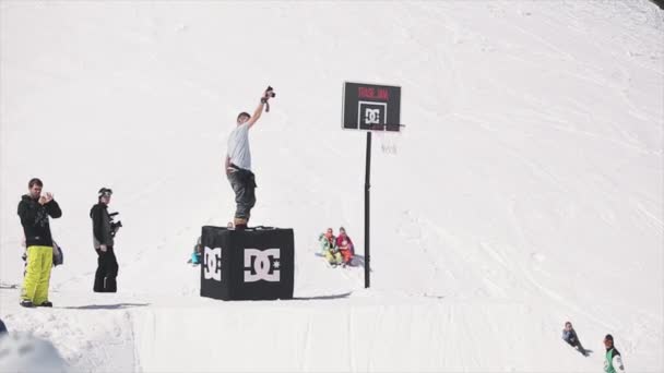 Sochi, Rusko-1, 2016: snowboardista na odrazový můstek házet míč do košíkového koše. Udělat kaskadér — Stock video
