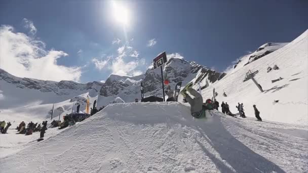 俄罗斯索契 - 2016年4月1日：滑雪板从跳板坠落。橙色球观众。滑雪胜地。阳光 — 图库视频影像