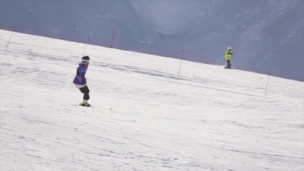 SOCHI, RÚSSIA - 1 de abril de 2016: Passeio de esqui no salto de inclinação do trampolim. Estância de esqui. Montanha nevada. Dia ensolarado — Vídeo de Stock