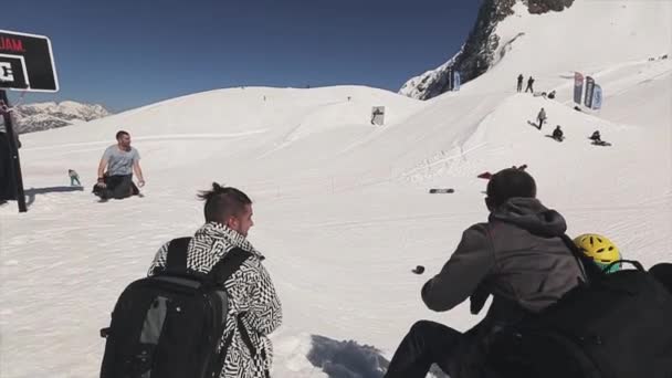SOCHI, RUSIA - 1 DE ABRIL DE 2016: Salto snowboarder sobre trampolín lanza pelota en canasta. Camarógrafo. Truco extremo — Vídeo de stock