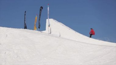 Soçi, Rusya - 1 Nisan 2016: Kayakçı olun yüksek atlama üzerinden sıçrama tahtası. Kayak Merkezi. Dağlar. Güneşli. Mavi gökyüzü.