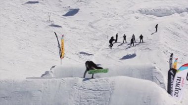 Soçi, Rusya - 1 Nisan 2016: Snowboarder sıçrama sıçrama tahtası, üzerinden başarısız. Kar dağlar. Güneşli bir gün. İnsanlar. Aşırı spor.