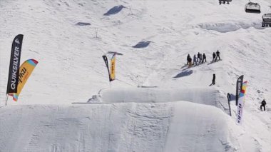 Soçi, Rusya - 1 Nisan 2016: Snowboarder yüksek atlama üzerinden sıçrama tahtası. Kar dağlar. Güneşli bir gün. Kayak Merkezi. İnsanlar. Aşırı spor