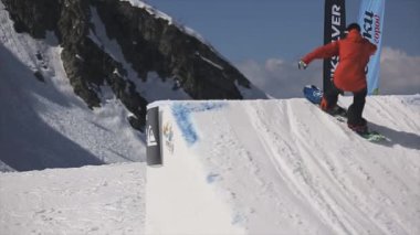 Soçi, Rusya - 1 Nisan 2016: Snowboarder yüksek atlama üzerinden sıçrama tahtası. Kurulu havada tut. Dağlar. Mavi gökyüzü