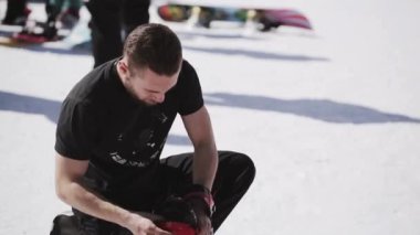 Soçi, Rusya - 1 Nisan 2016: Snowboard snowboard üzerinde gömlek düzeltme çizmeli. Kayak Merkezi. Encamp. Güneşli gün.