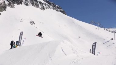 Sochi, Rusya Federasyonu - 1 Nisan 2016: Snowboarder yüksek atlama sıçrama tahtası üzerinden yapmak, havada dön. Kayak Merkezi. Kameraman