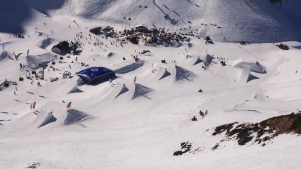 Soçi, Rusya - 1 Nisan 2016: Manzaraya güneşli sabah karlı dağlarda Kayak Merkezi. Kayakçı ve snowboard düşkünleri. Yamaçlarında. Sıçrama tahtası — Stok video