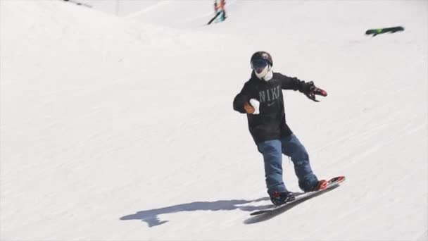 Sochi, Rusko - 1. dubna 2016: Snowboardista jízda na SpringBoardu házet sněhové koule do basketbalového koše. Lidé. — Stock video