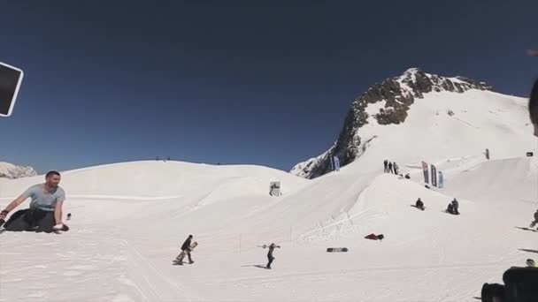 SOCHI, RÚSSIA - 1 de abril de 2016: Snowboarder jump on springboard try throw ball in basketball basket. Extremo . — Vídeo de Stock