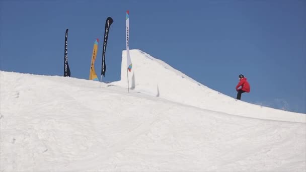 SOCHI, RUSSIA - APRIL 1, 2016: Skier make high jump from springboard. Ski resort. Mountains. Sunny. Blue sky. — Stock Video