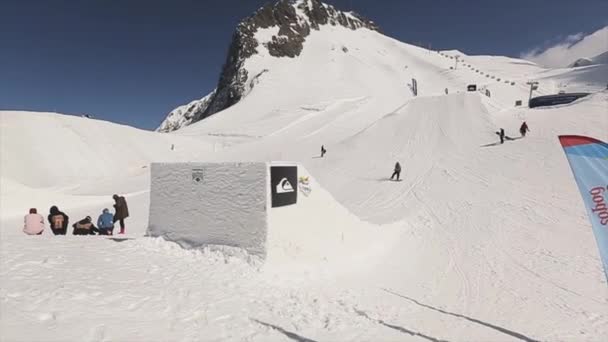 Soči, Rusko - 1. dubna 2016: Snowboardista jízdu mimo sjezdovky. Extrémní sport. Lidé. Zasněžené hory. Slunečno — Stock video