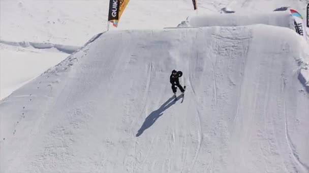 Sotschi, Russland - 1. April 2016: Skifahrer fahren auf dem Sprungbrett, machen Flip in der Luft. Schneebedeckte Berge. Skigebiet. sonniger Tag. Extrem — Stockvideo