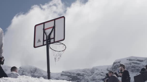 Snowboarder saltar de trampolim e joga bola em cesta. Montanhas nevadas. Dia ensolarado. Fracasso — Vídeo de Stock