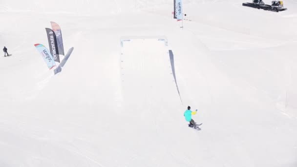 SOCHI, RUSSIA - APRILE 1, 2016: Snowboarder fare un salto in alto dal trampolino di lancio, girare intorno. Località sciistica. Estremo — Video Stock