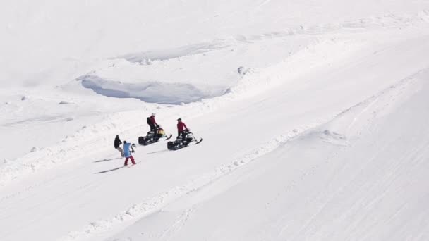 Sochi, Rusland - 1 April 2016: Snowboarder ritje op sneeuwscooter op helling. Skigebied. Cameraman. Bergen. — Stockvideo