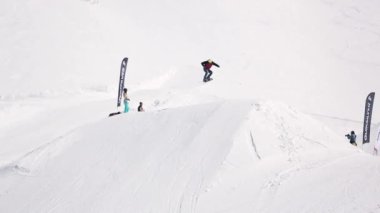 Sochi, Rusya Federasyonu - 1 Nisan 2016: Snowboard yapmak yüksek atlama üzerinden sıçrama tahtası, ayakları havada şişiriyor. Kayak Merkezi