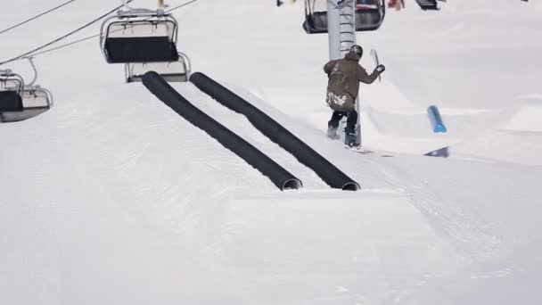 Sochi, Rusland - 1 April 2016: Snowboarder dia op zwarte pipes. Springplank. Skigebied. Bergen. Skiliften. — Stockvideo
