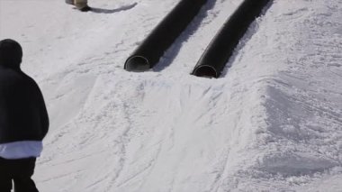 Soçi, Rusya - 1 Nisan 2016: Snowboarder slayt siyah borular üzerinde. Sıçrama tahtası. Kayak Merkezi. Dağlar. İnsanlar.