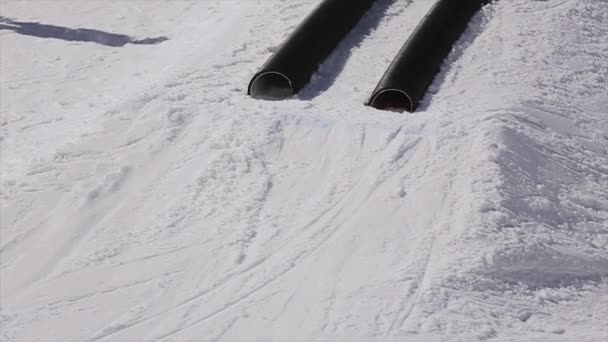 Sochi, Ryssland - April 1, 2016: Skidåkare tur på rören. Springboard. Skidorten. Bergen. Solig dag. Snowboardåkare — Stockvideo