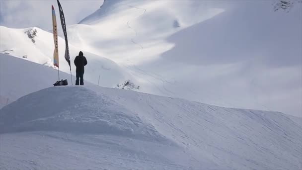 Sochi, Rusland - 1 April 2016: Snowboarder make hoogspringen van de Springplank, dia op helling. Skigebied. Extreme — Stockvideo