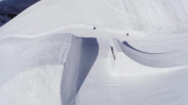 SOCHI, RUSIA - 2 DE ABRIL DE 2016: Quadrocopter disparar snowboarder salto de trampolín hacer voltereta. Montañas. Sol — Vídeo de stock