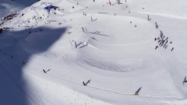 Sochi, Ryssland - April 2, 2016: Quadrocopter skjuta sluttningarna på skidorten. Språngbrädor. Snowboardåkare. Soligt. — Stockvideo