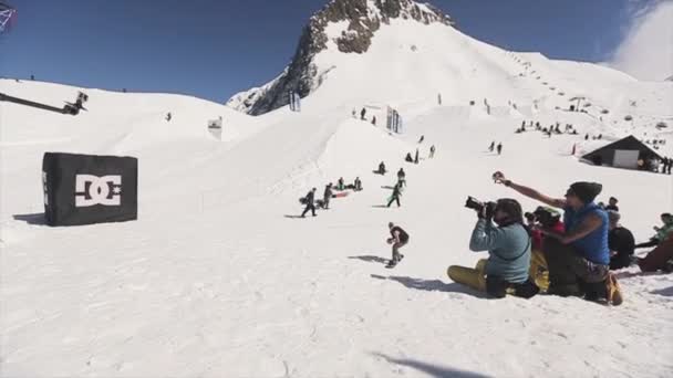 Sochi, Rusko - 1. dubna 2016: Snowboardista se skok na SpringBoardu hodit míč do koše. Lidé. Krajina. — Stock video