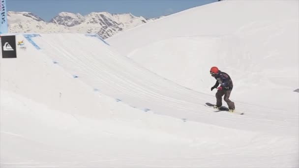 СОЧИ, РОССИЯ - 1 апреля 2016 года: Прыжок сноубордиста с трамплина делает флип в воздухе. Пейзаж снежной горы . — стоковое видео