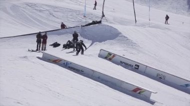 Sochi, Rusya Federasyonu - 2 Nisan 2016: Snowboarder demiryolu kayarsa, yapmak ters çevir. Kayak Merkezi. Güneşli bir gün. Dağlar.