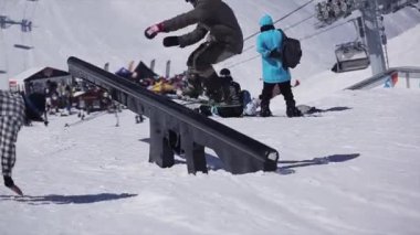 Soçi, Rusya - 2 Nisan 2016: Snowboard slayt üzerinde demiryolu üzerinde kayak merkezi. Güneşli bir gün. Karlı dağlar. Kameraman