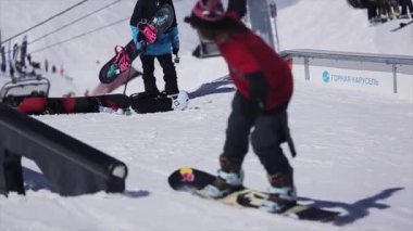 Soçi, Rusya - 2 Nisan 2016: Snowboarder slayt üzerinde demiryolu üzerinde kayak merkezi. Güneşli bir gün. Dağlar. İnsanlar. Aşırı
