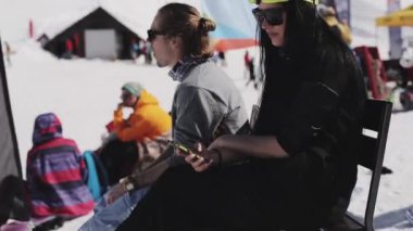 Sochi, Rusya Federasyonu - 2 Nisan 2016: Kız güneş gözlüğü ve çocuk dinlenmek diğer insanlar arasında encamp. Kayak Merkezi. Gülümseme