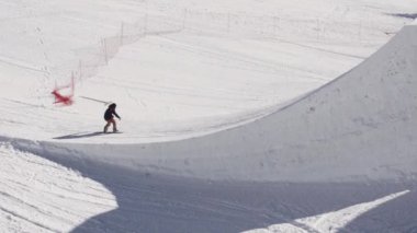 Soçi, Rusya - 2 Nisan 2016: Snowboarder sıçrama tahtası binmek. Tam flip havada olun. Güneşli. Kayak Merkezi. Spor