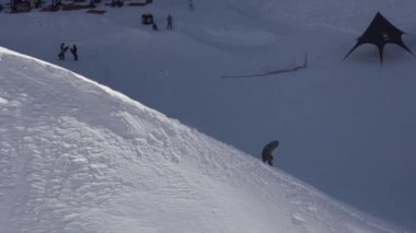 Sochi, Rusya - 2 Nisan 2016: Karlı yamaç Snowboarder slayt aşağı. Güneşli bir gün. Kayak Merkezi. İnsanlar. Aşırı