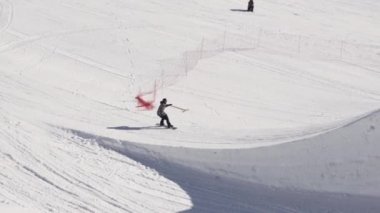 Soçi, Rusya - 2 Nisan 2016: Snowboarder sıçrama tahtası binmek. Flip, havada kurulu kapmak olun. Güneşli. Kayak Merkezi