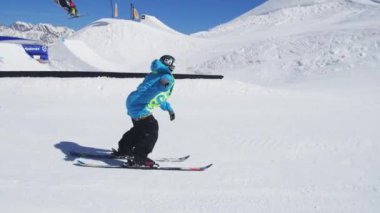 Soçi, Rusya - 2 Nisan 2016: Kayakçı yamaç, slayt Ray üzerinde binmek. Güneşli bir gün. Kayak Merkezi. Karlı dağlar.