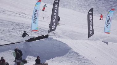 Sochi, Rusya Federasyonu - 2 Nisan 2016: Snowboarder sıçrama sıçrama tahtası, üzerinden yapmak Kayak Merkezi üzerinde fiske vurmak. Dağlar. At Binme