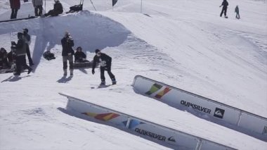 Sochi, Rusya Federasyonu - 2 Nisan 2016: Snowboarder kötüyola demiryolu üzerinde kayak merkezi. Güneşli bir gün. Karlı dağlar. İnsanlar