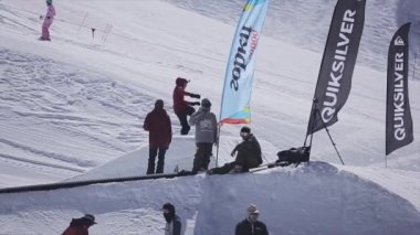 Soçi, Rusya - 2 Nisan 2016: Snowboarder atlama kayak merkezi sıçrama tahtası. Güneşli bir gün. Karlı dağlar