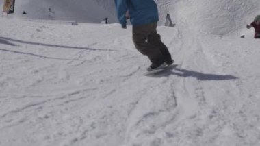 Snowboard izini sürmek. Kameraman. Manzara karlı dağlar. Güneşli bir gün. İnsanlar. Aşırı. Stunts
