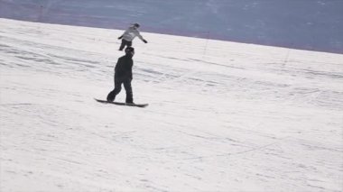 Soçi, Rusya - 1 Nisan 2016: Snowboard Sürüş yamaç, sıçrama tahtası atlamak. Kayak Merkezi. El kaldırsın. Güneşli