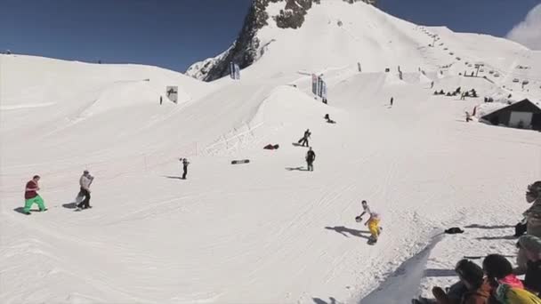 Sochi, Ryssland - den 1 April 2016: Snowboardåkare gör hoppa på springboard kasta vit hjälm i korg. Personer. — Stockvideo