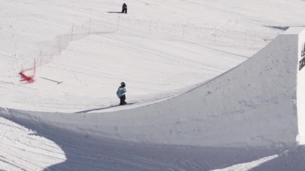 Sochi, Rusland - 2 April 2016: Skiër rit op Springplank. Maak stunt in de lucht. Zonnige dag. Skigebied. Mensen. — Stockvideo