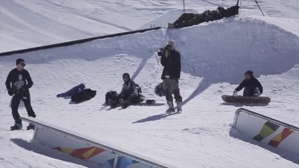 SOCHI, RUSSIE - 2 AVRIL 2016 : glissement du snowboardeur sur rail. Station de ski. Journée ensoleillée. Des cascades extrêmes. Sport actif — Video