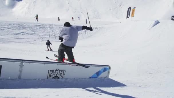 SOCHI, RUSSIE - 2 AVRIL 2016 : Le skieur glisse sur le rail, fait des flips. Journée ensoleillée. Station de ski. Des montagnes. Sport extrême — Video